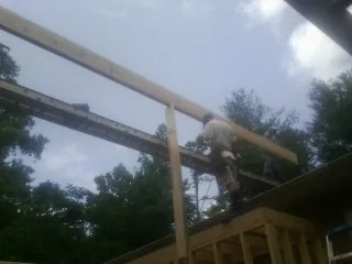 Carpenter setting a ridge beam over a new addition frame — Ice Dam Removal by Roofing Brothers in Wilmot