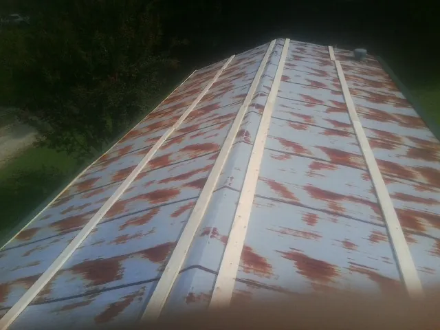 Rusted metal roof panels with new wood purlins before replacement — Storm Damage Roof Repair in Wilmot by Roofing Brothers