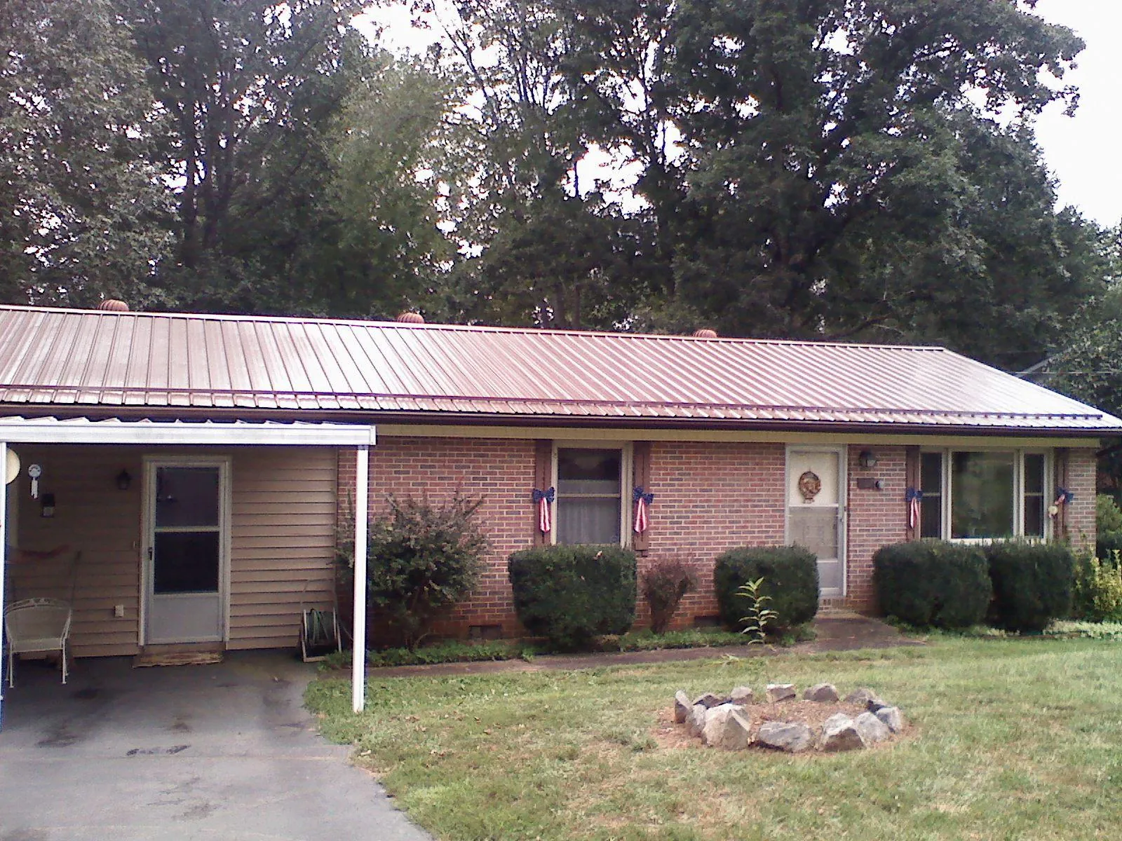 Bronze metal roof and carport on a brick ranch home — Roof Repair work by our crew in Wilmot