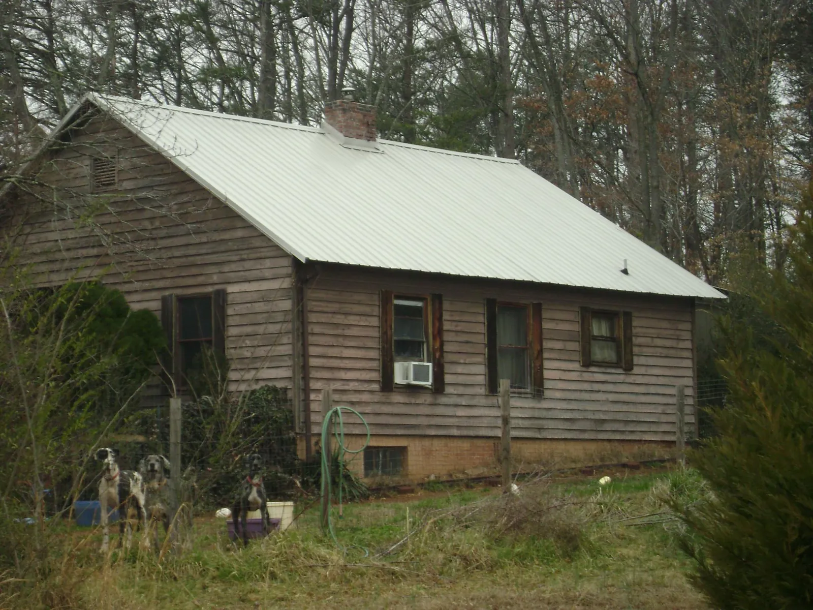White metal roof on an old wood sided farmhouse, from a Metal Roof Installation job in Wilmot
